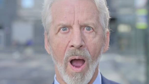Zbliżenie na twarz starego biznesmena z wstrząśniętym wyrazem twarzy — Wideo stockowe