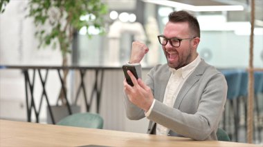 Ofisteki Akıllı Telefon 'da Başarıyı Kutlayan Kafkas Genç Adam