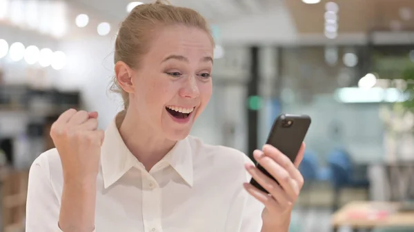 Porträt einer aufgeregten Geschäftsfrau, die ihren Erfolg auf dem Smartphone feiert — Stockfoto