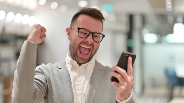 兴奋的白人年轻人在智能手机上庆祝成功 — 图库照片