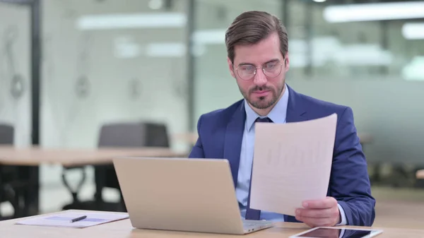 Affärsman som arbetar på laptop med dokument i Office — Stockfoto