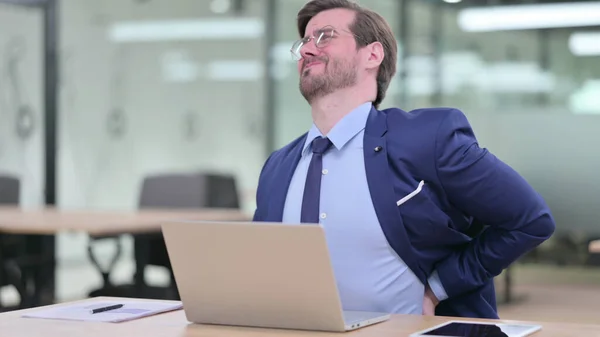 Hardworking Young Businessman with Laptop having Back Pain in Office — Stock Photo, Image