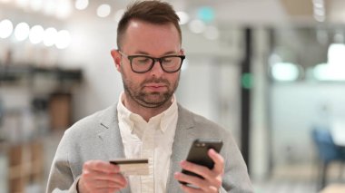 Beyazlı Genç Adam Çevrimiçi Akıllı Telefon Alışverişi Yapıyor