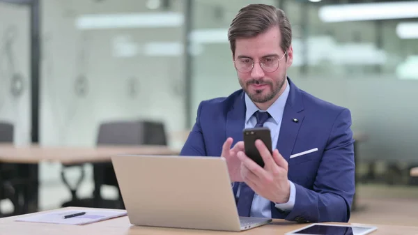 Businessman Navegar por Internet en el teléfono y el ordenador portátil —  Fotos de Stock