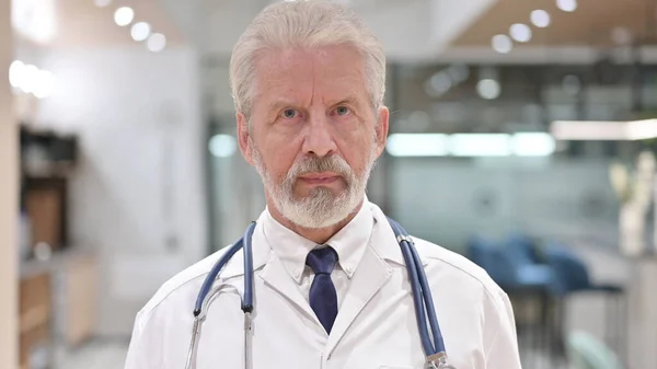 Retrato do médico velho profissional Olhando para a câmera — Fotografia de Stock