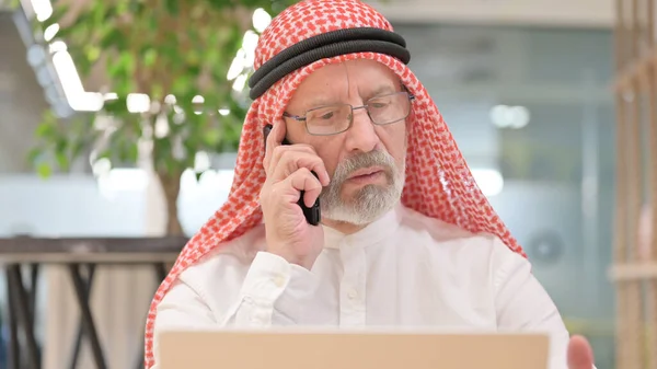 Dizüstü bilgisayarlı, telefonda konuşan yaşlı Arap İşadamının Kapanışı — Stok fotoğraf