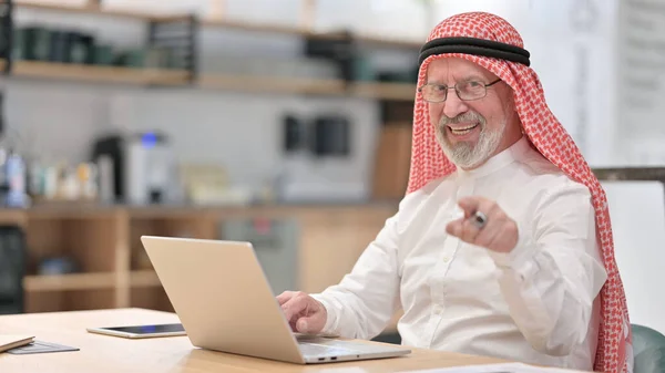 Bilgisayarlı yaşlı Arap İşadamı kamerayı işaret ediyor. — Stok fotoğraf