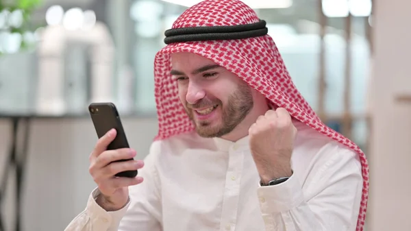 Homme d'affaires arabe célèbre le succès sur Smartphone au bureau — Photo