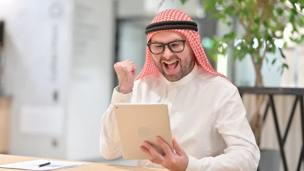 Succesvolle jonge Arabische man viert feest op Tablet — Stockfoto