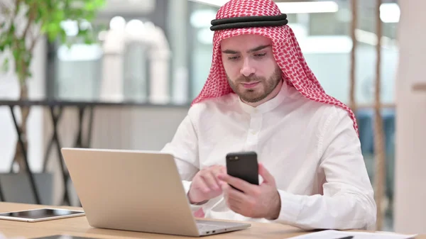 Arab Businessman Περιήγηση στο Internet για Smartphone και Laptop στο Γραφείο — Φωτογραφία Αρχείου