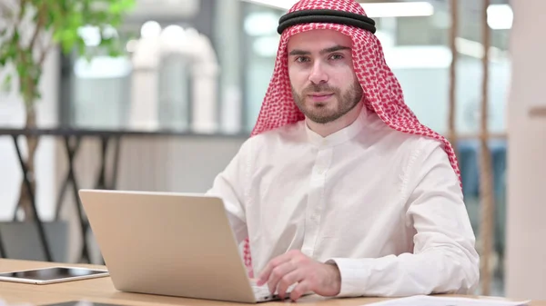 Expressionless Arab Businessman with Laptop Looking at Camera — Stock Photo, Image