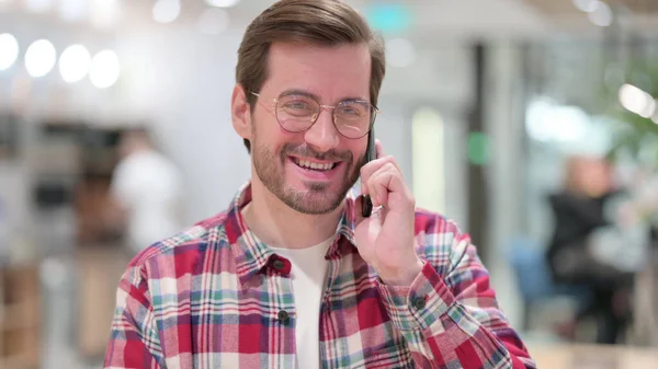 Portrét veselého mladého muže mluvícího po telefonu — Stock fotografie