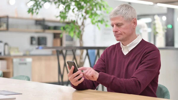 Middelbare leeftijd zakenman surfen op Internet op smartphone — Stockfoto
