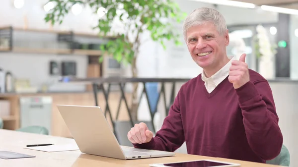 Old businessman with Laptop showing Thumbs Up