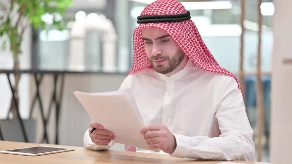 Arab Businessman Reading Documents in Office