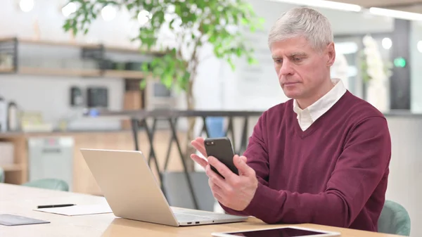 Moyen Age Homme d'affaires Naviguer sur Internet sur Smartphone au travail — Photo