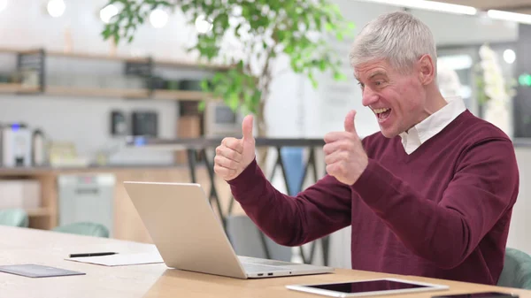 Geschäftsmann mittleren Alters feiert Erfolg am Laptop — Stockfoto