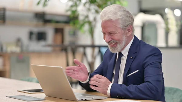 Starý podnikatel dělá video chat na notebooku v kanceláři — Stock fotografie