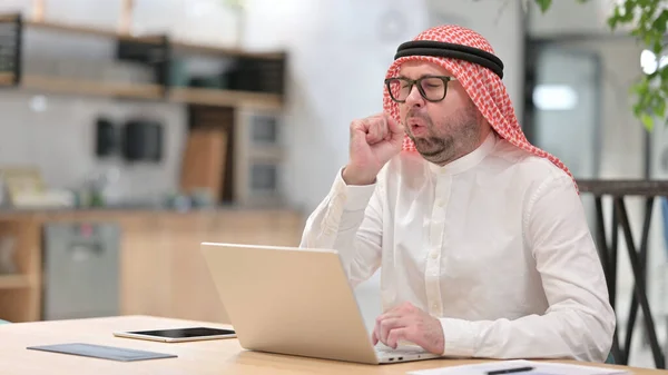 Nemocný mladý Arab muž s laptopem kašel — Stock fotografie