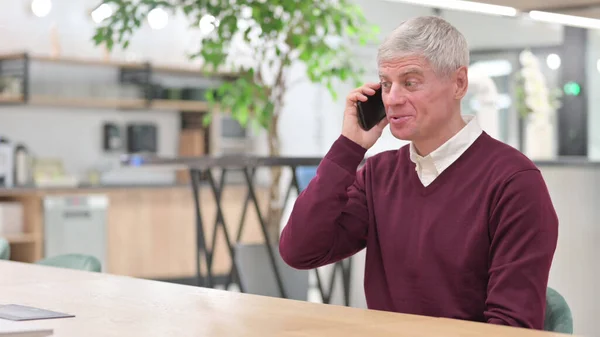 Empresário de meia-idade conversando por telefone — Fotografia de Stock