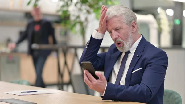 Triste velho empresário com falha em Smartphone no escritório — Fotografia de Stock