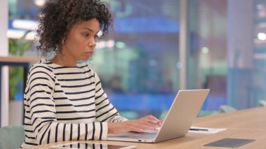 Ofiste Dizüstü bilgisayarda çalışan odaklanmış Afrikalı Kadın