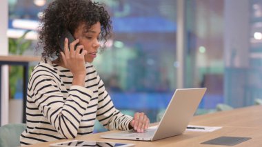 Ofiste dizüstü bilgisayarlı Afrikalı Kadın Konuşuyor