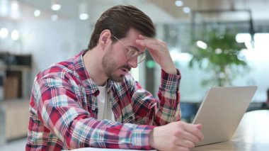 Kayıp Genç Adam dizüstü bilgisayarın önünde oturuyor.