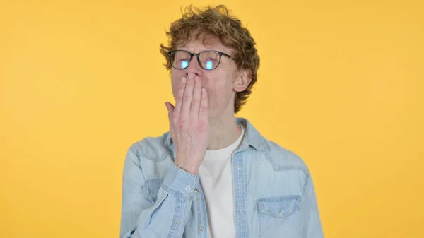 Bostezo pelirrojo joven sobre fondo amarillo —  Fotos de Stock