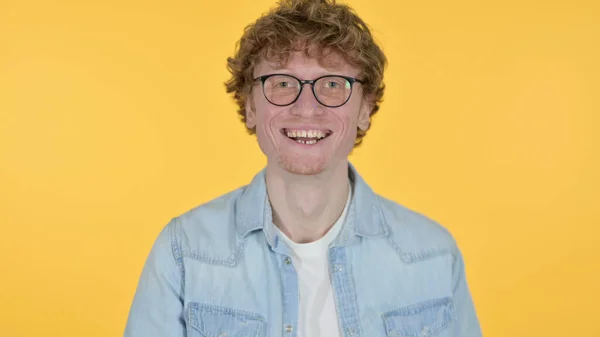 Ruiva jovem homem rindo na brincadeira em fundo amarelo — Fotografia de Stock