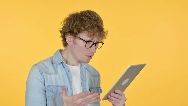 Rotschopf junger Mann verliert auf Tablet auf gelbem Hintergrund — Stockfoto