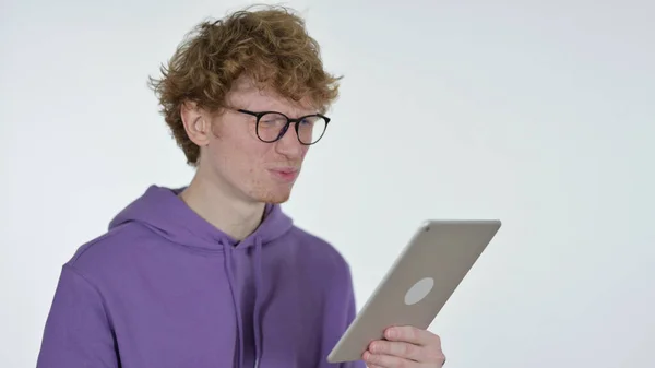 Falen op tablet door roodharige jongeman op witte achtergrond — Stockfoto