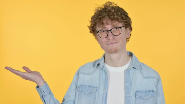 Espaço de cópia, Ruiva Jovem Mostrando Produto à Mão em Fundo Amarelo — Fotografia de Stock