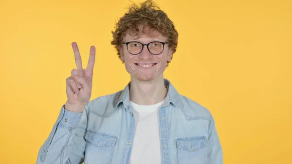 Victory Sign by Redhead Young Man on Yellow Background — Stock Photo, Image