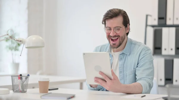 Hombre exitoso celebrando en la tableta en el trabajo — Foto de Stock