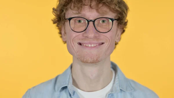 Gros plan du jeune homme rousse souriant sur fond jaune — Photo