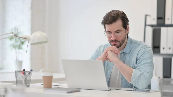 Ung man med bärbar dator tänker på jobbet — Stockfoto