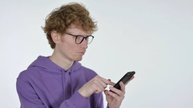 Kızıl Saçlı Genç Adam Beyaz Arkaplanda Akıllı Telefona Bakıyor