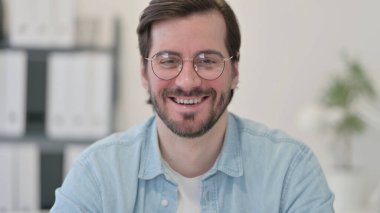 Kameraya gülümseyen genç adamın portresi