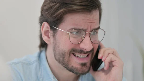 Close-up van boze jongeman praten op telefoon — Stockfoto