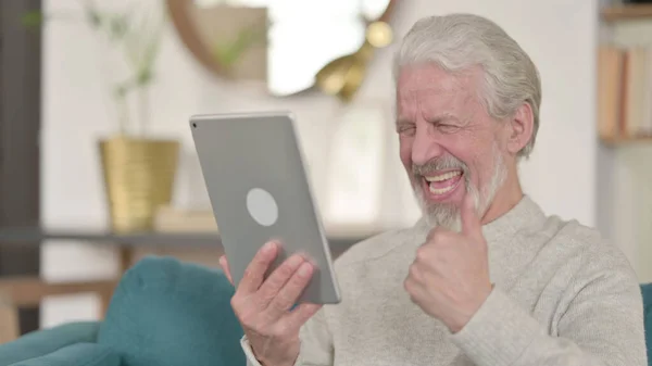 Vieil homme âgé célébrant sur tablette à la maison — Photo