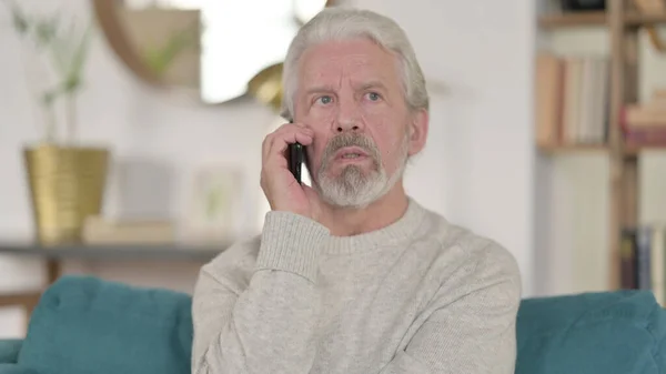 Старший старик разговаривает по телефону — стоковое фото