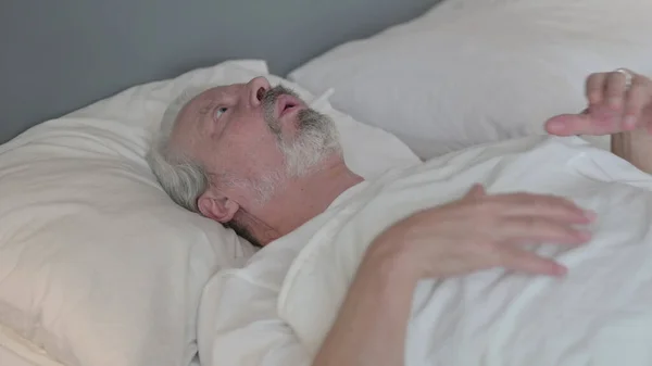Starszy staruszek budzi się z koszmaru w łóżku — Zdjęcie stockowe