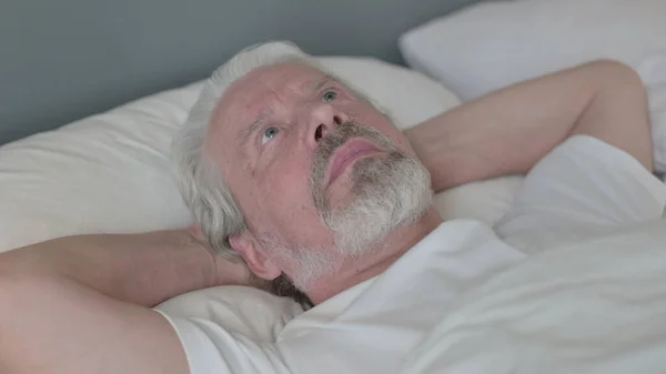 Schwerer älterer Mann liegt wach im Bett — Stockfoto