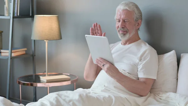 Online Video Chat on Tablet by Senior Old Man in Bed