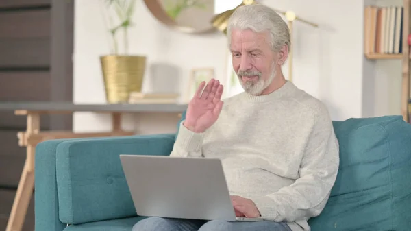 Онлайн видео-звонок на ноутбуке от старшего старика дома — стоковое фото