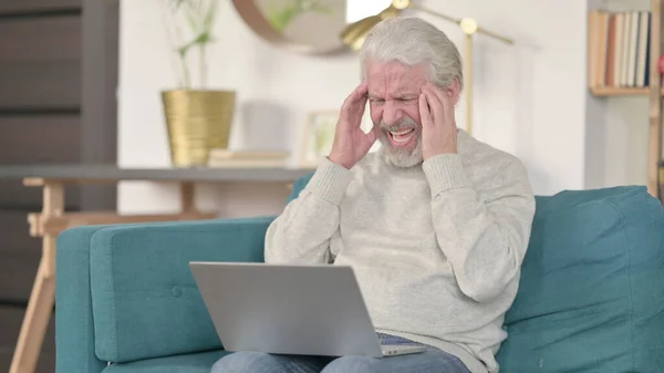 Idős öregember laptoppal, akinek otthon fáj a feje — Stock Fotó