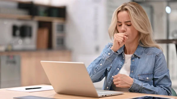 Junge Gelegenheitsfrau mit Laptop bei der Arbeit hustet — Stockfoto