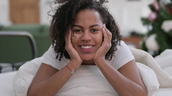 Close up de Jovem Africano Mulher sorrindo para a câmera na cama — Fotografia de Stock