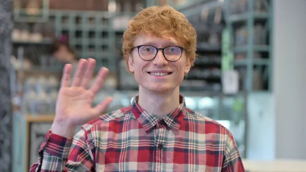 Portrait of Welcoming Young Redhead Young Man Waving at the Camera — Stock Photo, Image